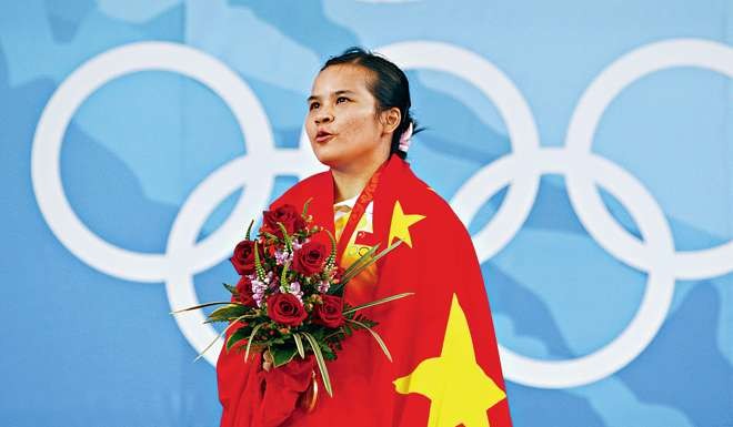 Chen Xiexia sings the national anthem after receiving her gold medal for setting an Olympic record of 117kg in winning the women's 48kg Group A clean and jerk. Photo: Reuters