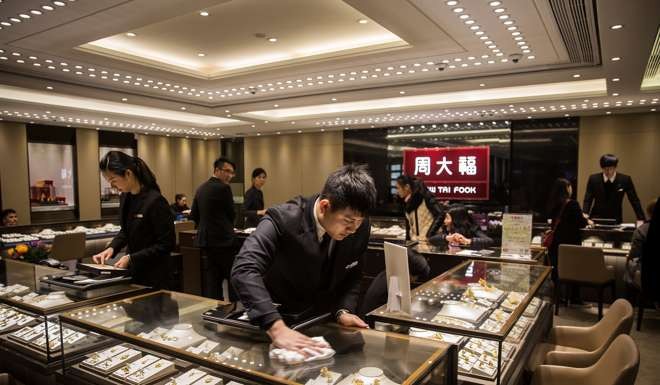 An employee cleaning a display cabinet containing gold jewellery at a Chow Tai Fook store in Hong Kong. Photo: Bloomberg