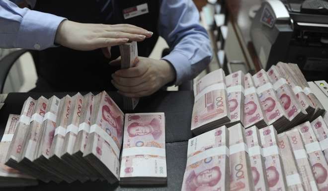 An employee counts 100 yuan notes at a bank in Hefei, Anhui province. Even if growth is hit by a trade war, China would be likely to put its huge surplus to use to halt the slide. Photo: Reuters