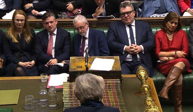 Britain's opposition Labour Party leader Jeremy Corbyn (centre) listens as British Prime Minister Theresa May (front) answers questions in the House of Commons. Photo: AFP