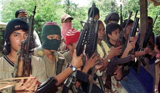 File photo shows Abu Sayyaf gunmen displaying their weapons in their jungle camp in Jolo in the southern Philippines. The militant group’s leaders have sowrn allegiance to Islamic State. Photo: AFP