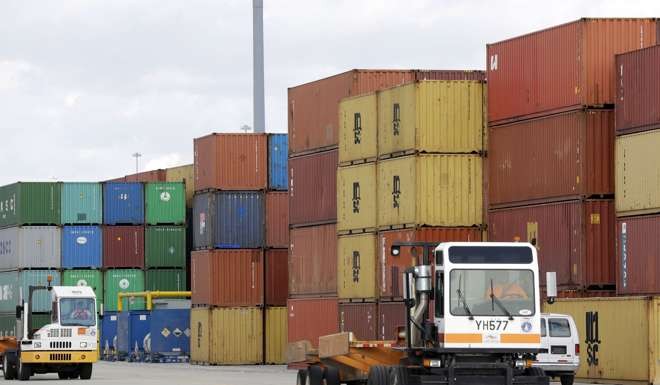 Trucks drive past shipping containers at the Port of Baltimore in Baltimore. Photo: AP