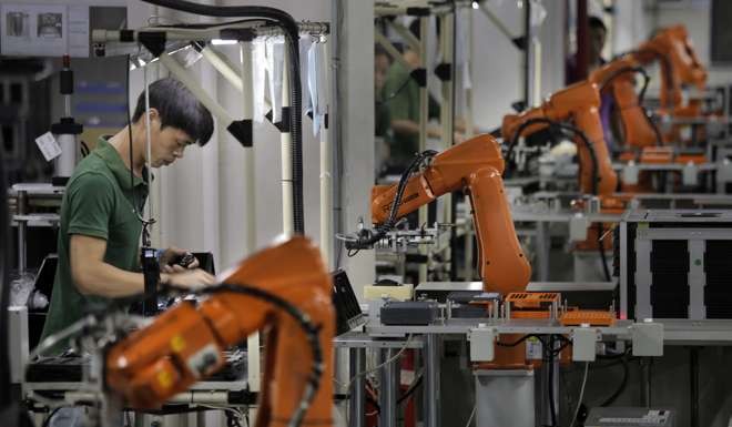 A man works amid orange robot arms at Rapoo Technology factory in the southern Chinese industrial boomtown of Shenzhen. The job market has changed globally, with manufacturing and office administration work having fallen due to globalisation and automation. Photo: AP