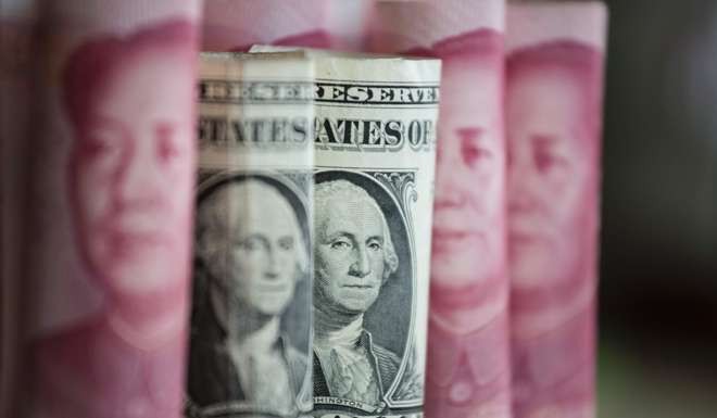 Chinese 100 yuan notes and US dollar notes. Photo: AFP