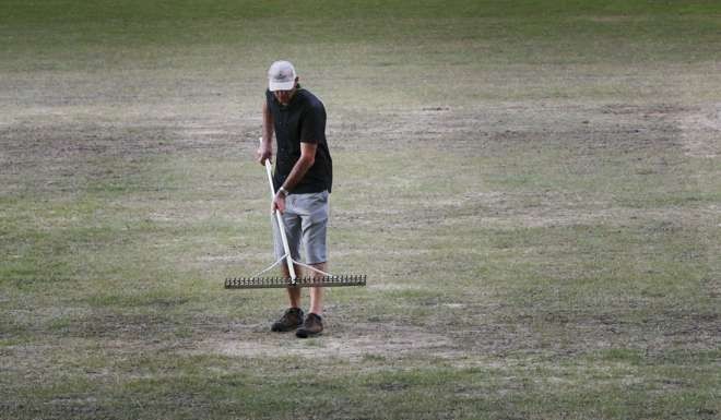 A worker tries to salvage the Hong Kong Stadium pitch in 2013. Photo: SCMP