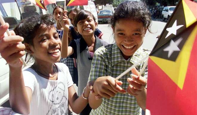 East Timorese children wave their country's flag. Photo: Reuters