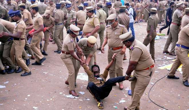Police remove a demonstrator from Marina beach. Photo: Reuters