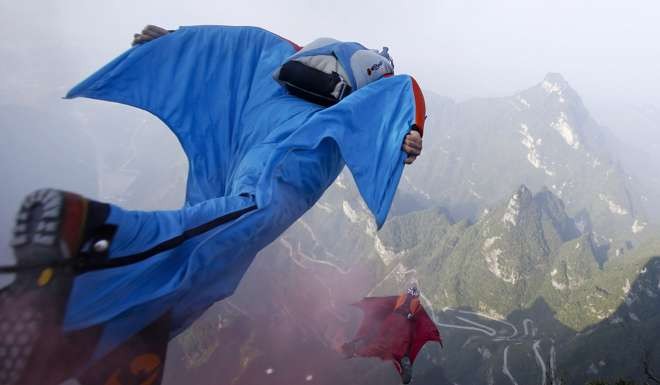 In this 2013 photo, wingsuited contestants jump off a mountain at Tianmen Mountain National Forest Park during training. Photo: AP