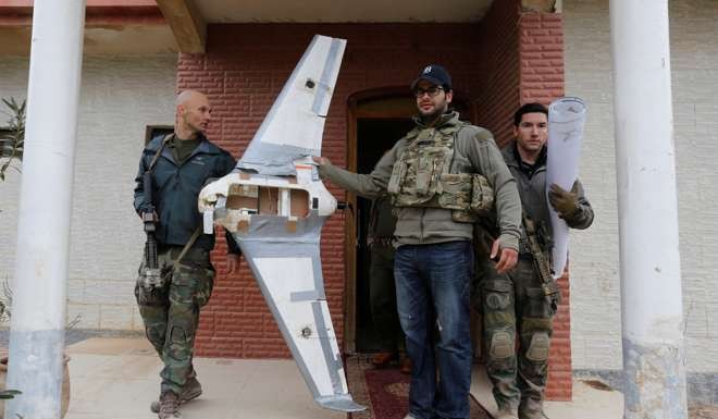 A US Special Operations Forces member inspects a drone used by Islamic State militants to drop explosives on Iraqi forces, in Mosul, Iraq. Photo: Reuters
