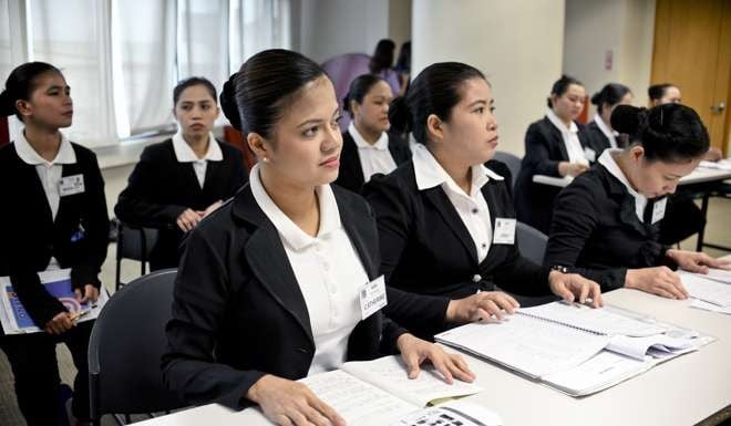 Trainee housekeeper Catherine Carrasco, front, attends a Japanese language class. Photo: Bloomberg