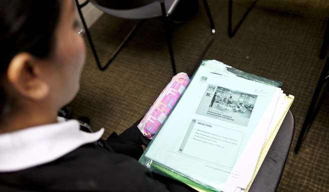A trainee housekeeper studies child care learning materials. Photo: Bloomberg