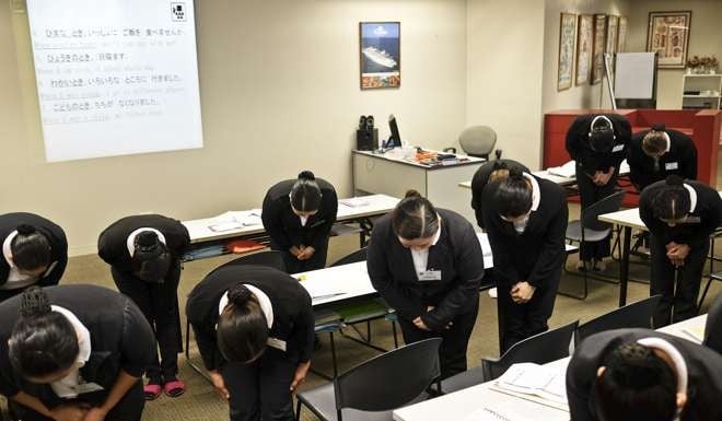 Trainee housekeepers bow during a training session in Manila. Photo: Bloomberg