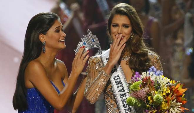 Miss Universe 2015 Pia Wurtzbach, left, prepares to crown Iris Mittenaere of France shortly after being proclaimed Miss Universe. Photo: AFP