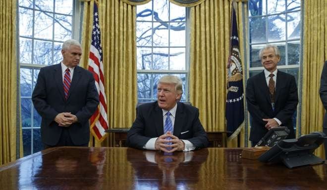 US President Donald Trump gets ready to sign three executive orders, flanked by White House National Trade Council adviser Peter Navarro, right, and Vice-President Mike Pence, at the Oval Office on January 23. Photo: AP