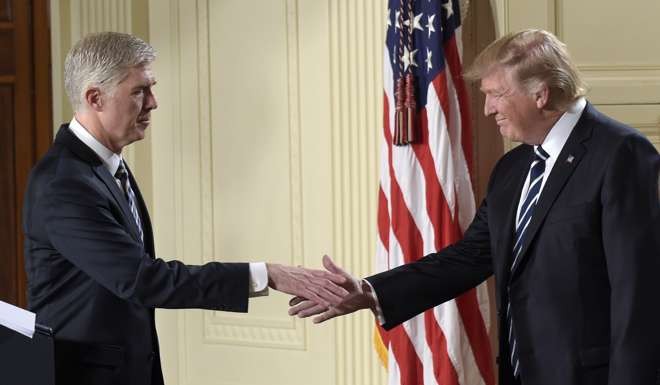 10th US Circuit Court of Appeals Judge Neil Gorsuch reaches to shake hands with President Donald Trump after his announcement as Trump's choice for Supreme Court Justice. Photo: AP