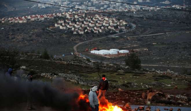 Protesters burn tyres at the entrance to the Israeli settler outpost of Amona in the occupied West Bank early Wednesday mornin. Photo: Reuters