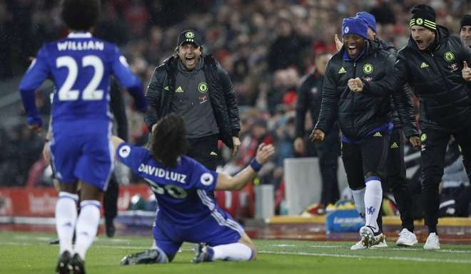 Chelsea’s David Luiz celebrates scoring the opening goal after catching Liverpool napping from a free kick.