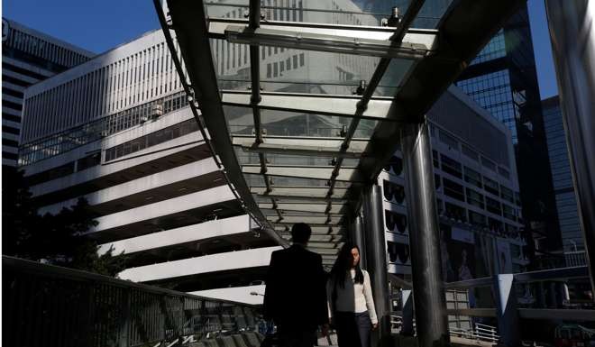 People walk on a footbridge in front of a multi-storey car park in Central. Underground development should be considered, and planned carefully, as part of a holistic approach to improving walkability and public space in Hong Kong. Photo: Reuters