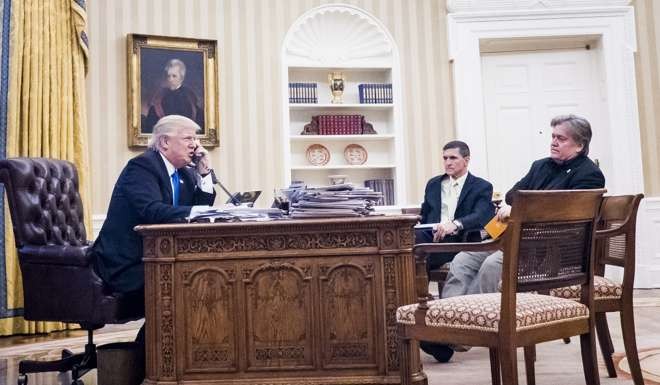 US National Security Advisor Michael Flynn (centre) and Senior Counsellor to the President Steve Bannon (right), listen as US President Donald Trump speaks on the phone with Prime Minister of Australia Malcolm Turnbull in the Oval Office on January 28. Photo: EPA