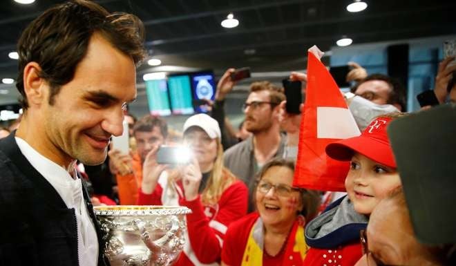 Roger Federer shows off his trophy on returning to his native Switzerland. Photo: Reuters