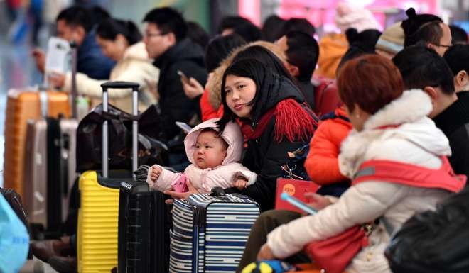 A mother soothes her young child as they wait for trains at Shijiazhuang station, the capital of north China's Hebei Province. Photo: Xinhua