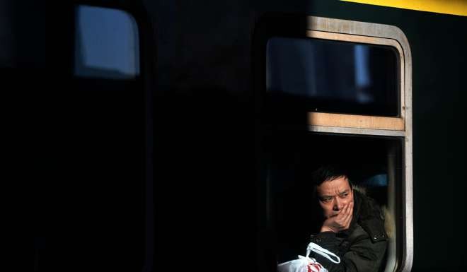 Finally, a seat: a passenger waits for departure on a train at the Harbin Railway Station. Photo: Xinhua