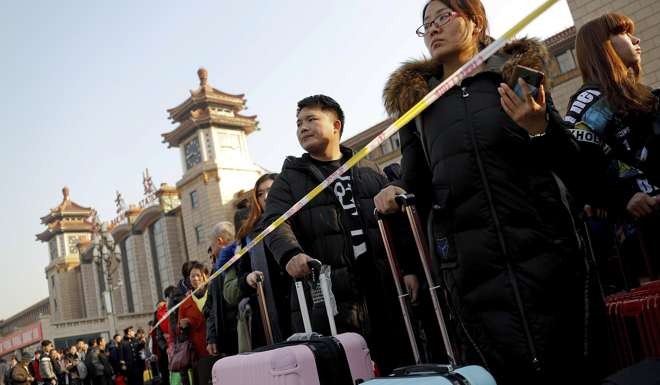 People line up to get into a subway at the Beijing railway station. Photo: AP